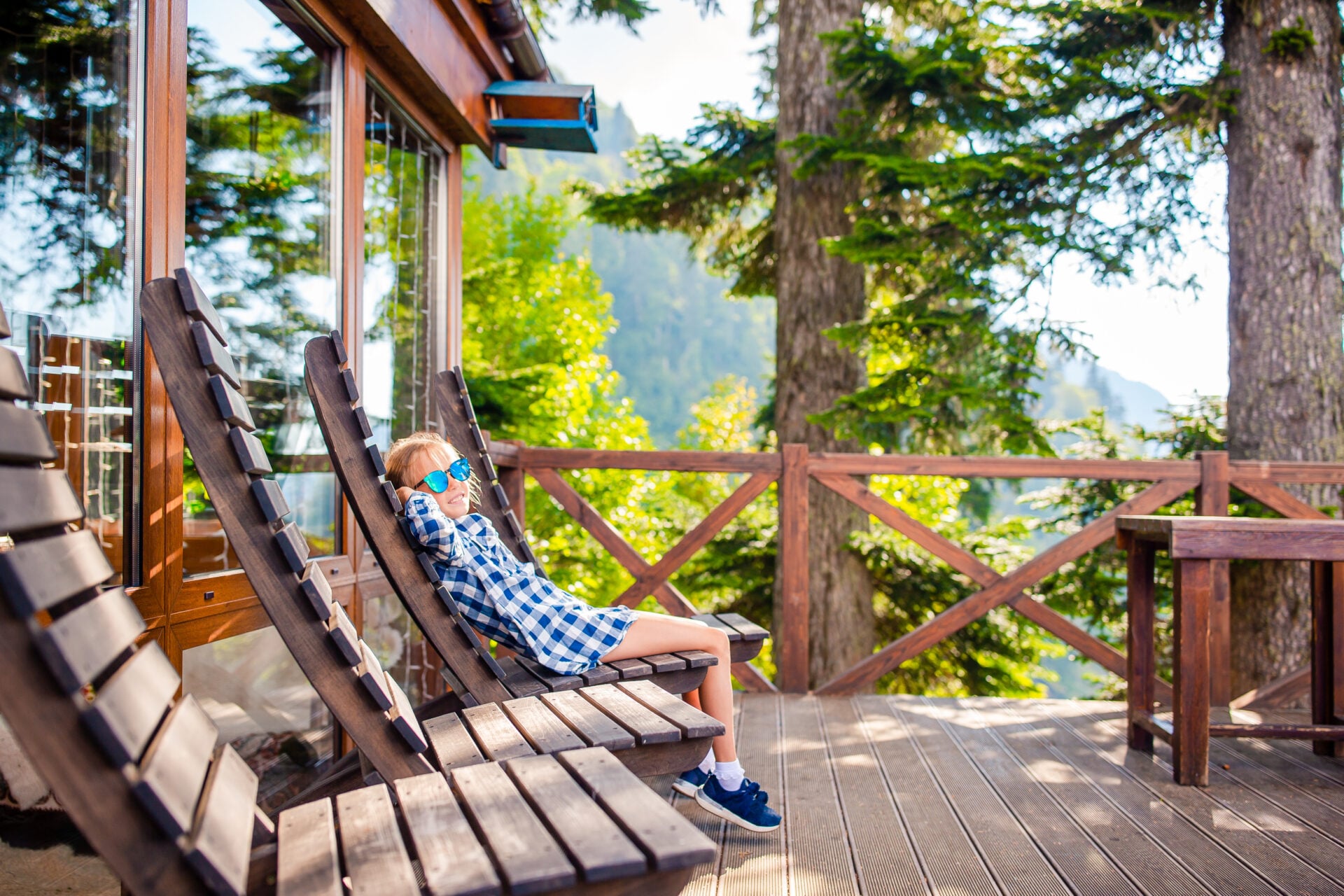 Little kid in mountains in the amazing restaraunt with beautiful view. Beautful landscape