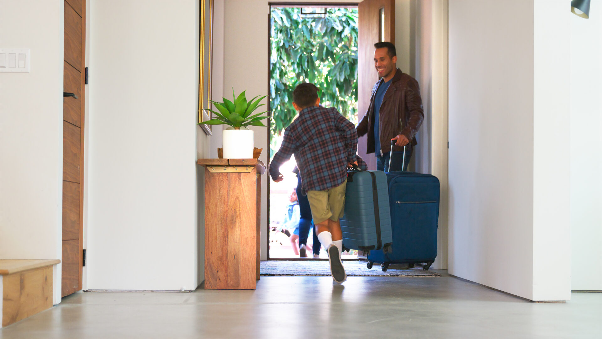 Family With Luggage Opening Door And Leaving Home For Vacation